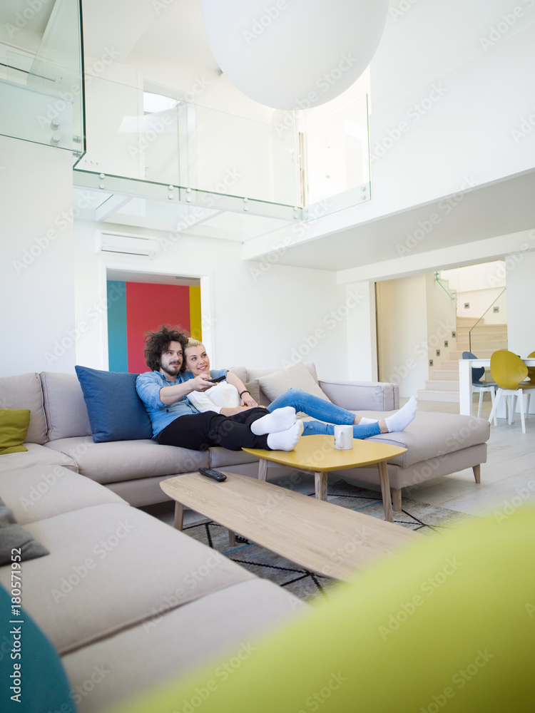 Young couple on the sofa watching television Young couple on the sofa watching television