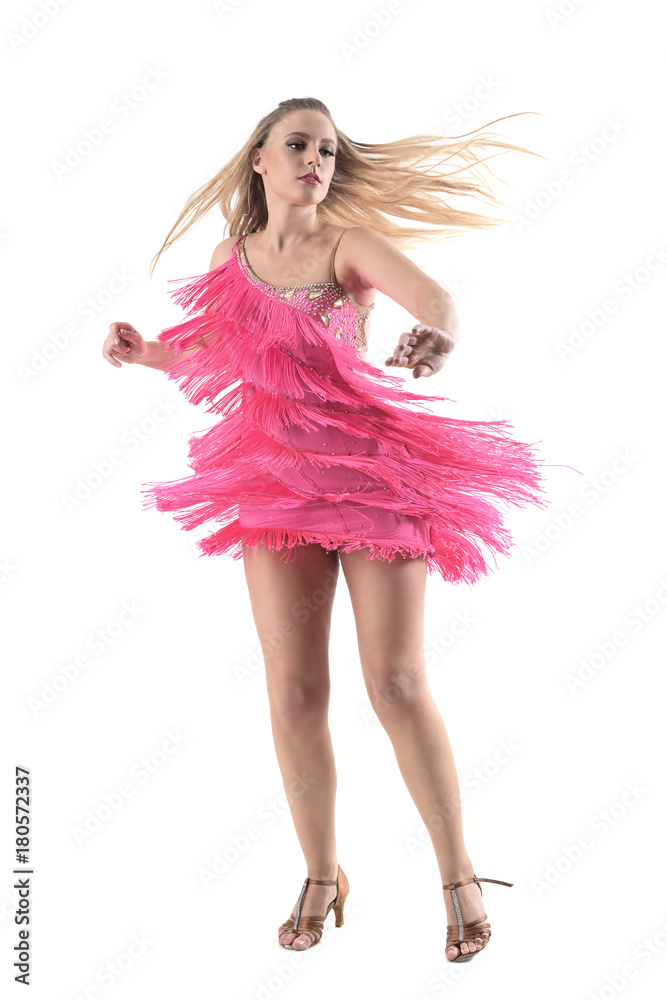 Frozen motion front view of blonde female Latin dancer spinning with hair flow looking away. Full body length portrait isolated on white background. Frozen motion front view of blonde female Latin dancer spinning with hair flow looking away. Full body length portrait isolated on white background.