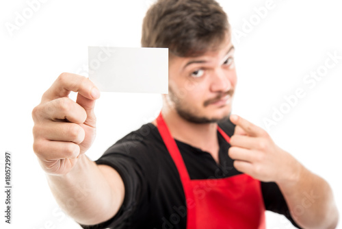 Selective focus of supermarket employer holding business and pointing