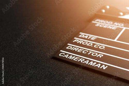 closeup clapboard  on black table with soft-focus and over light in the background