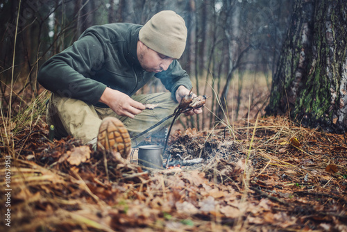 quail on the stick grilled in the fire. delicious forest picnic. bushcraft concept