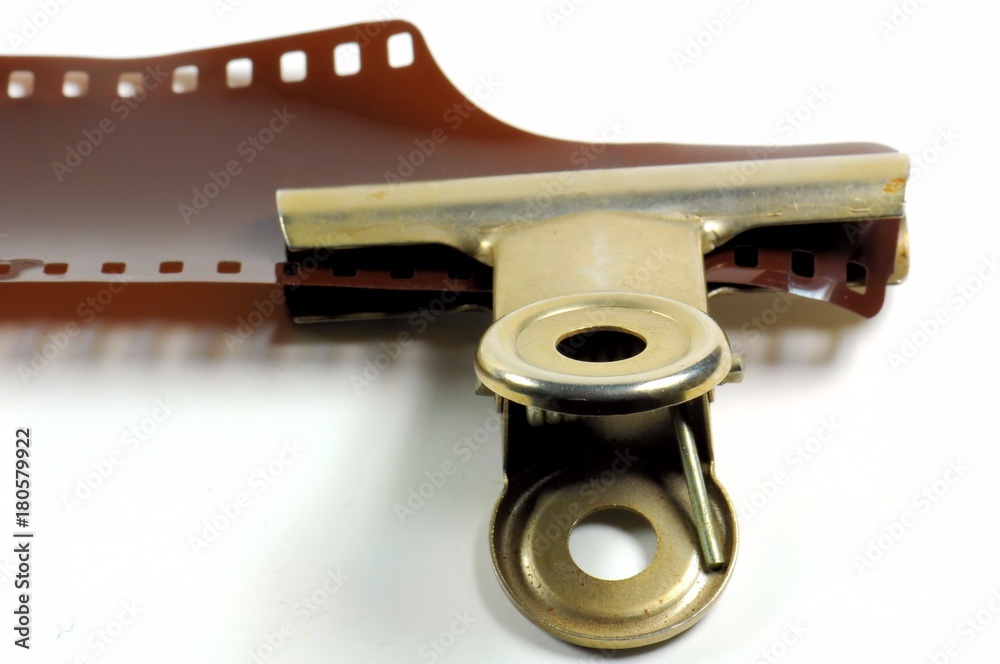 Film strip on a white background with metal clip. Film strip on a white background with metal clip.