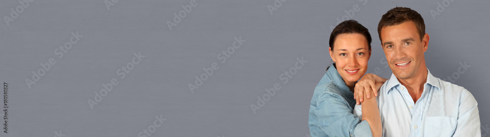 Happy couple standing on grey background- banner template web Happy couple standing on grey background- banner template web