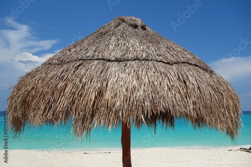 A palapa thatched palm tree sun umbrella on the beach in Cancun  Mexico