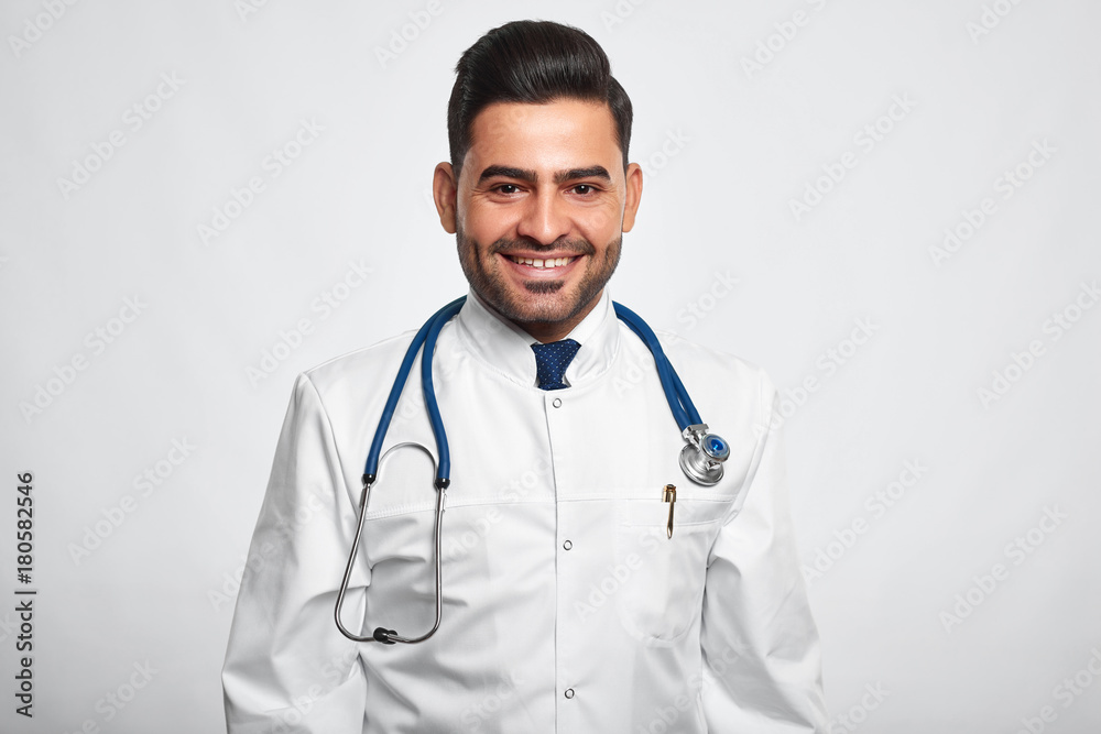 Fototapeta premium Studio shot of a happy handsome male doctor smiling cheerfully posing at studio copyspace happiness vitality health living profession occupation job success survey good news.