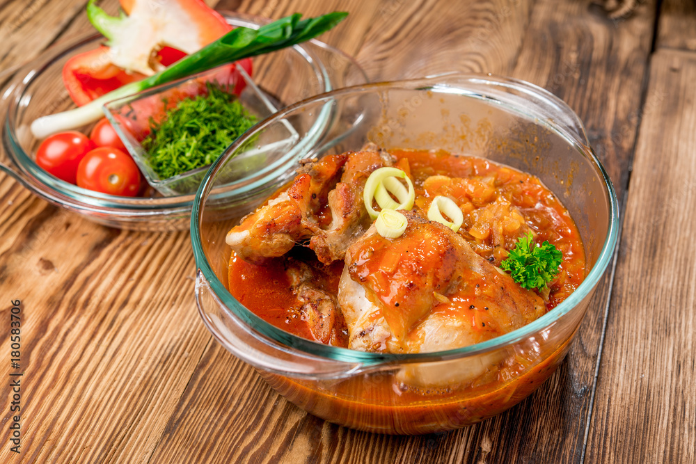 Roasted rabbit with herbs, tomato sauce and glass of wine on a plate. Roasted rabbit with herbs, tomato sauce and glass of wine on a plate.