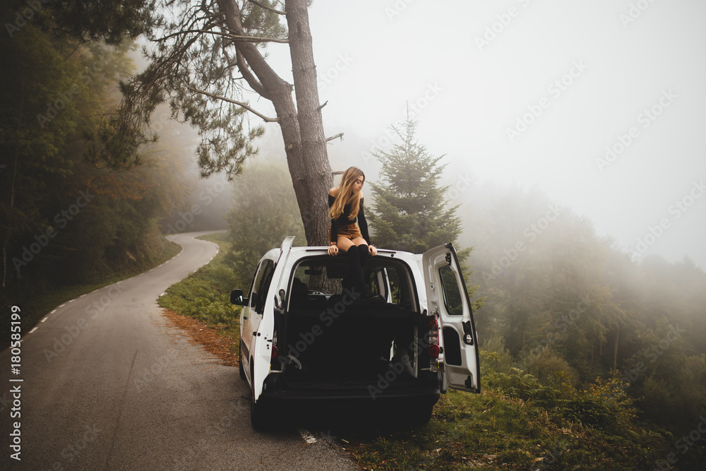© Gerard Moral/ADDICTIVE STOCK - Woman sitting on top of car