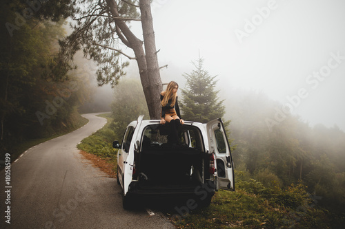 Woman sitting on top of car photo