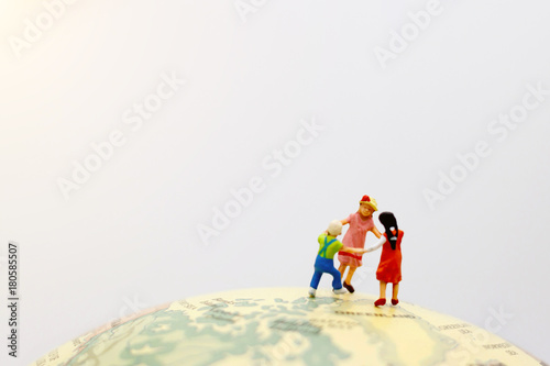 Playful children holding hands on the globe..