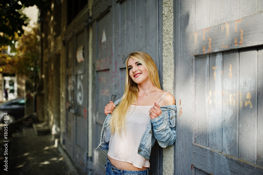 Obraz premium Blonde girl wear on jeans jacket posed at street.