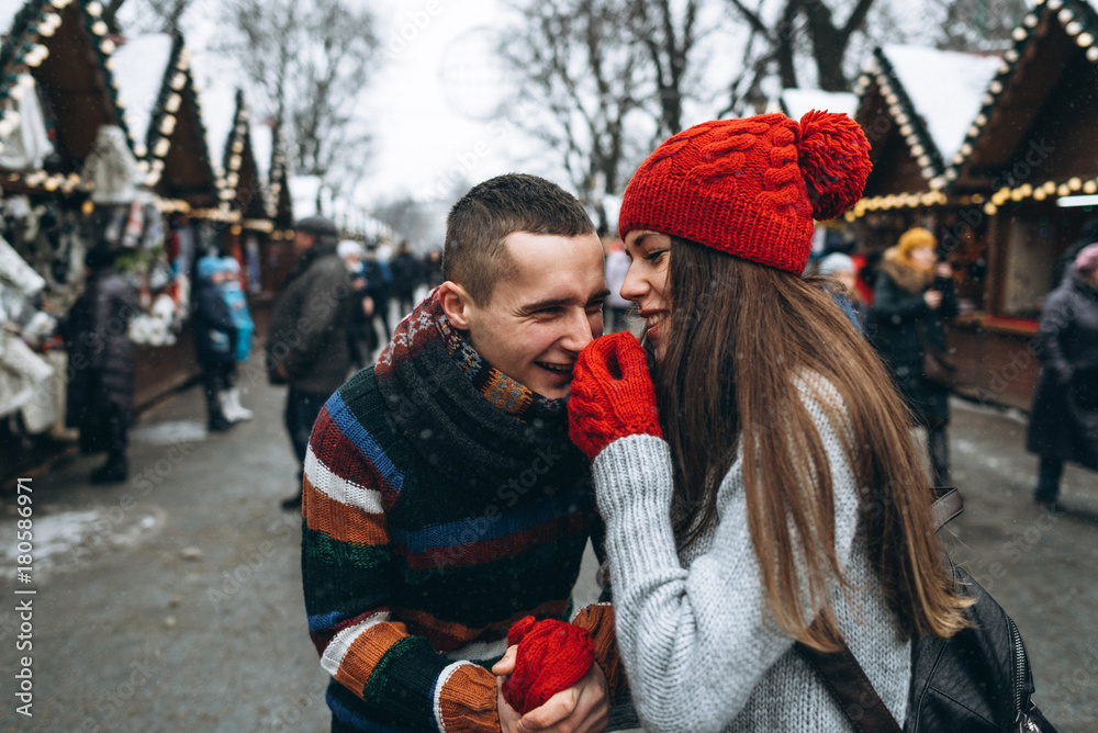 Obraz premium Young couple outside having fun in winter christmas decoration