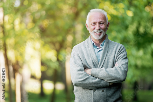 Elderly man smiling outdoors in nature 