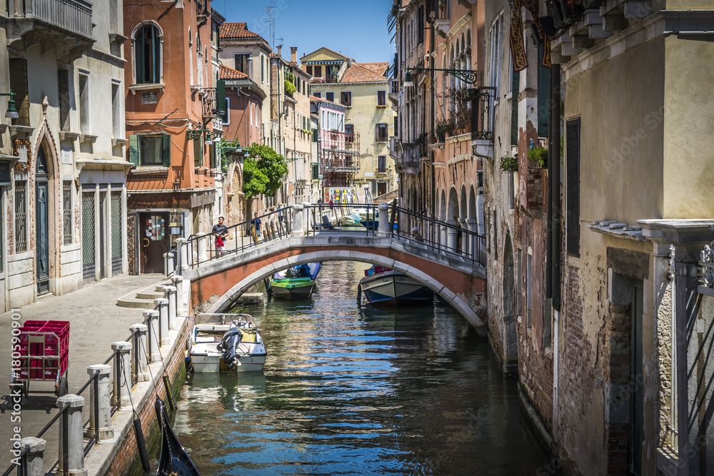 Canals and historic buildings of Venice, Italy. Narrow canals, old houses, reflection on water on a summer day in  Venice, Italy.