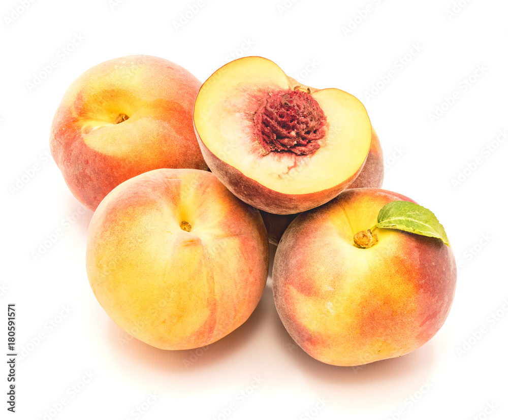 Folded peaches, one with green leaf and one sliced half with a stone, isolated on white background. Folded peaches, one with green leaf and one sliced half with a stone, isolated on white background.