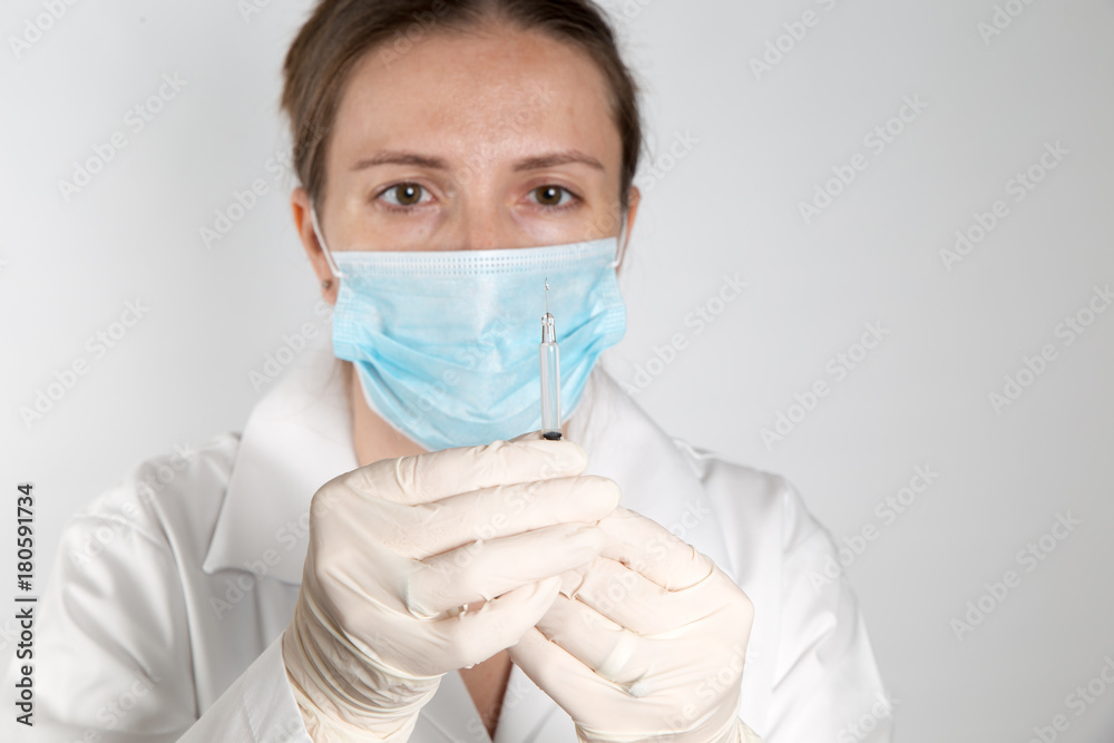 Close up of a female doctor or nurse preparing an injection or vaccine
