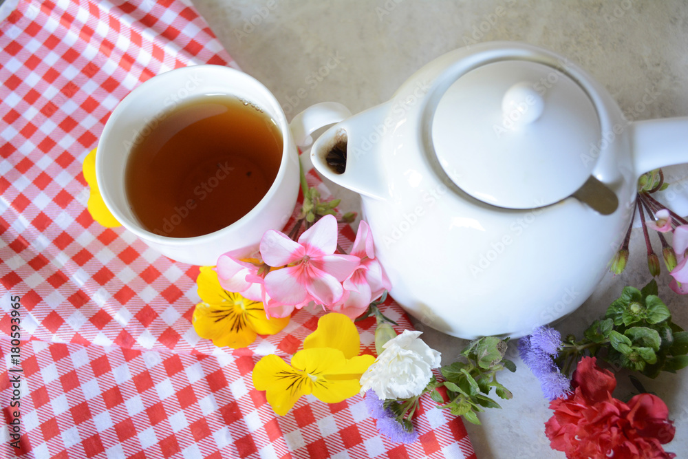 Cup of tea among the different colors collected in the spring blooming garden creates a mood Cup of tea among the different colors collected in the spring blooming garden creates a mood