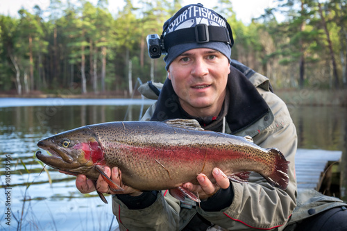 Autumn portrait of angler and trophy fish