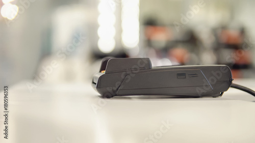 payment terminal on the table on blurred shop background