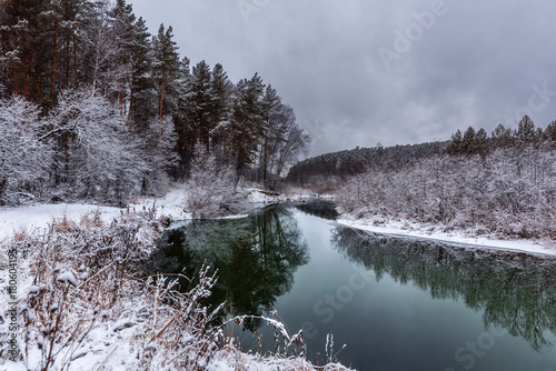A cooling river with the first snow on the shore