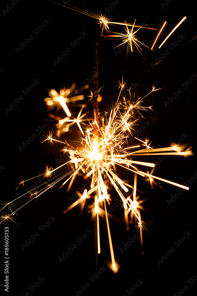 Burning sparkler isolated on black background