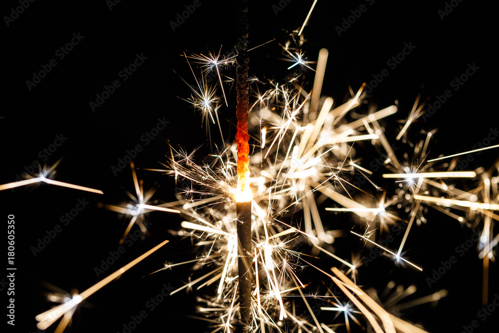 Fototapeta premium Burning sparkler isolated on black background blur