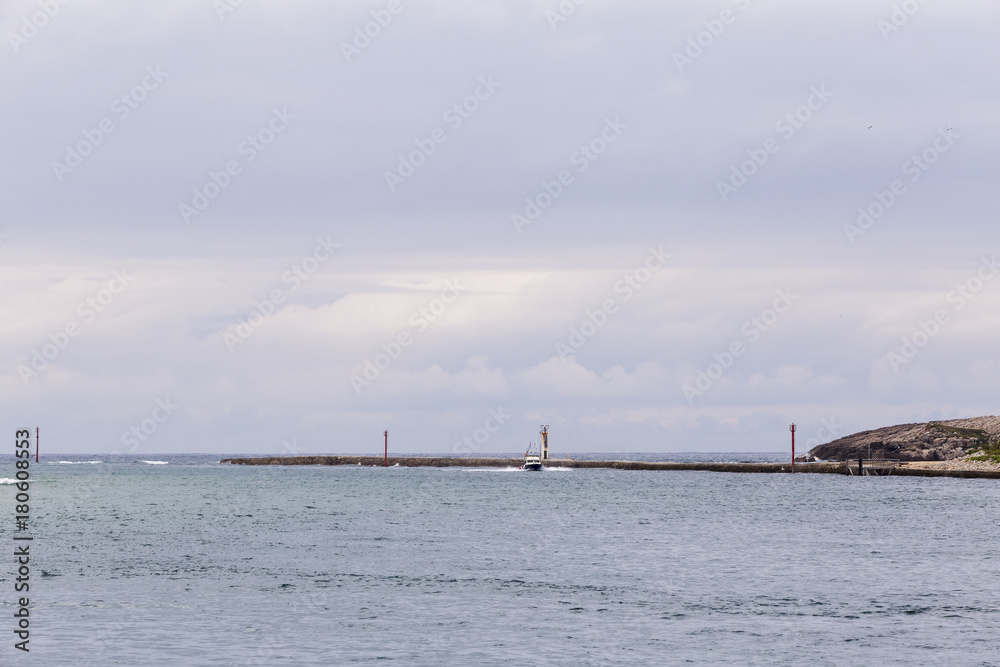 entrance to a port on the coast on a cloudy day
