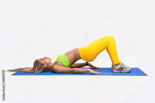 Young sportswoman training on mat