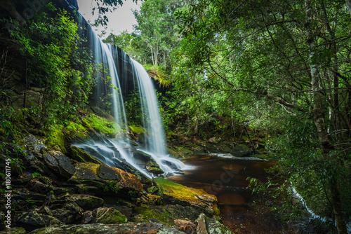 Waterfall with green moss in the tropical rainforest landscape