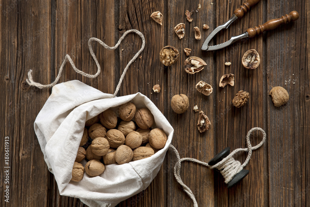 Walnuts, Nutcracker and Christmas decor with wooden background. Top view, close-up Walnuts, Nutcracker and Christmas decor with wooden background. Top view, close-up