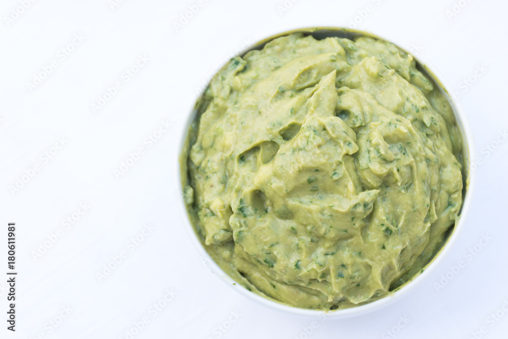 Obraz premium Bowl of tasty homemade guacamole, green avocado dip on white background