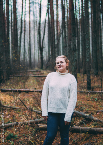 woman with white sweater and glasses in a cloudy forest © pavelkant