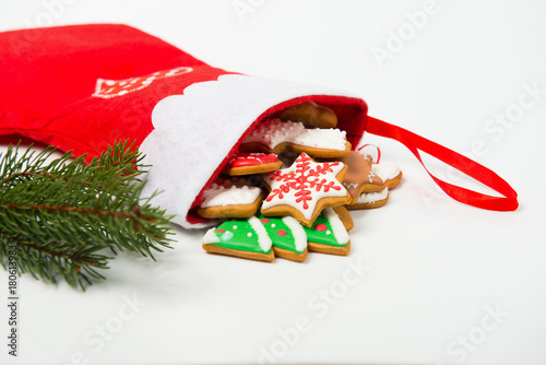 Christmas concept. Christmas sock with gingerbread and christmas tree branch on white background