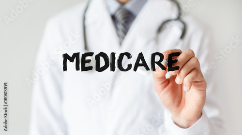 Doctor writing word MEDICARE with marker, Medical concept photo