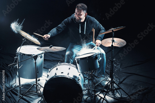 Drummer rehearsing on drums before rock concert. Man recording music on drum set in studio photo
