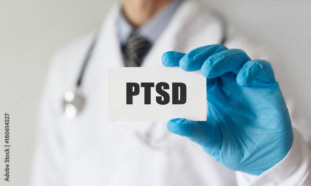 Doctor holding a card with text PTSD, medical concept Doctor holding a card with text PTSD, medical concept
