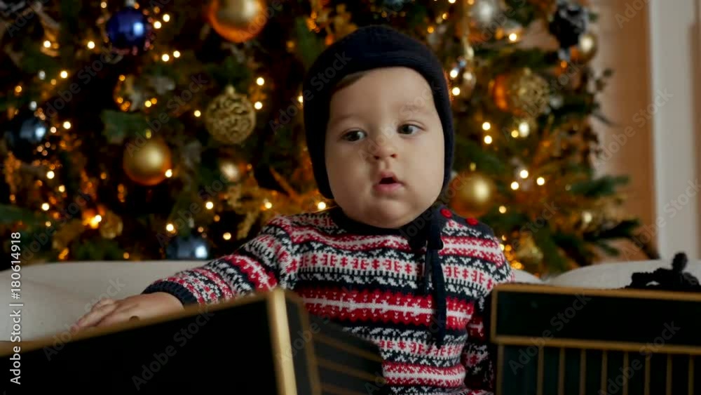 child sitting on sofa with gift boxes in a Christmas tree child sitting on sofa with gift boxes in a Christmas tree