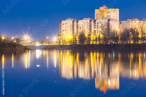 Night View Of Urban Residential Area Overlooks To City Lake Or River Park