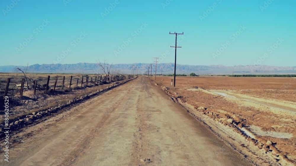 Empty Dirt Road Drive / Slow moving shot of a dirt road with power poles. Empty Dirt Road Drive / Slow moving shot of a dirt road with power poles.