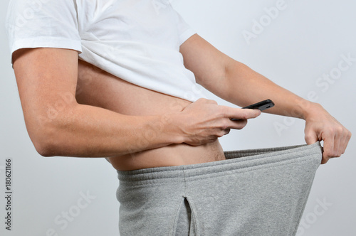 Man taking a picture of his penis with a smart-phone Fotobehang
