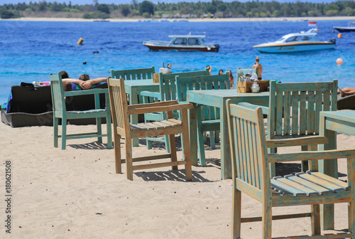 Verwitterte blaue Tische und Stühle eines Restaurants am Strand der Insel Trawangan, Gili Islands (Indonesien)