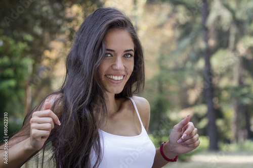 Wallpaper Mural Young beautiful girl sitting at the park and smile Torontodigital.ca