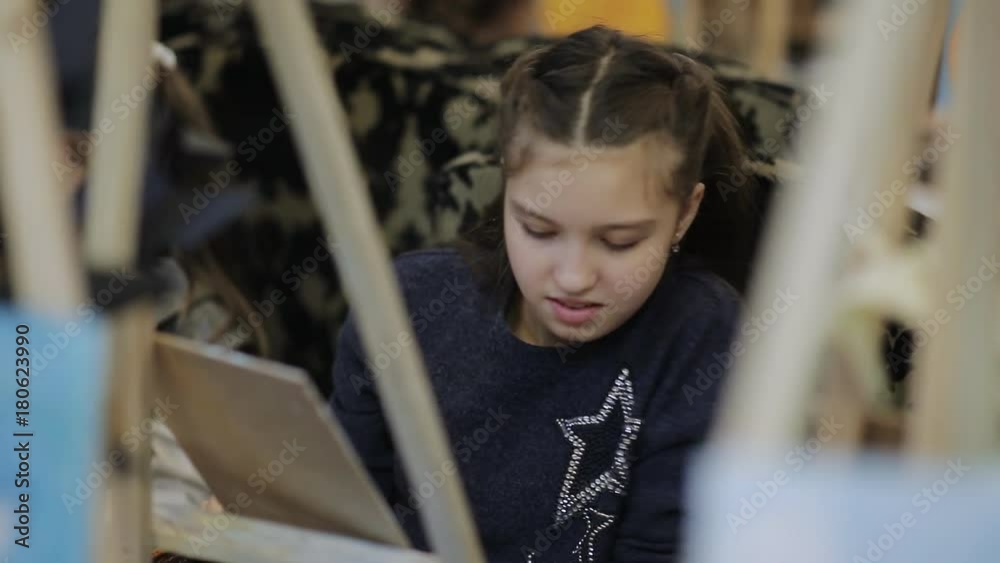 art school, a group of children with easels paint a painting with brushes and paints