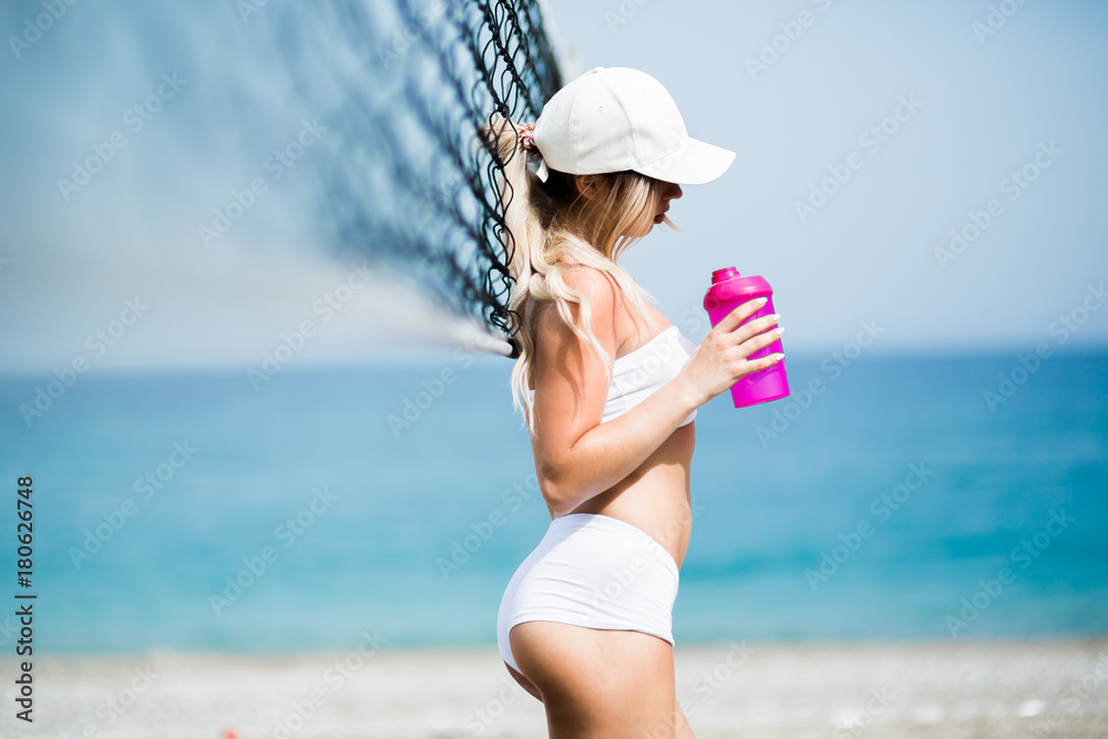 Refreshing after workout. Beautiful young blonde woman in sports clothing drinking water Refreshing after workout. Beautiful young blonde woman in sports clothing drinking water
