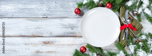 Christmas Table place setting on rustic white wood with snow tipped fir branches