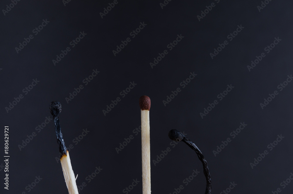 Three matches on a black background Three matches on a black background