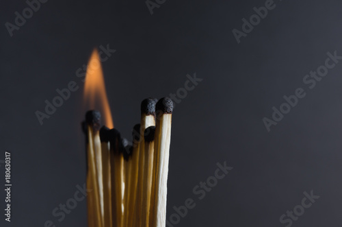 Burning matchstick on black background