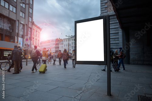 Fototapeta Naklejka Na Ścianę i Meble -  Vertical blank billboard in the city center with Mock up. The layout is located in a crowded street with people.
