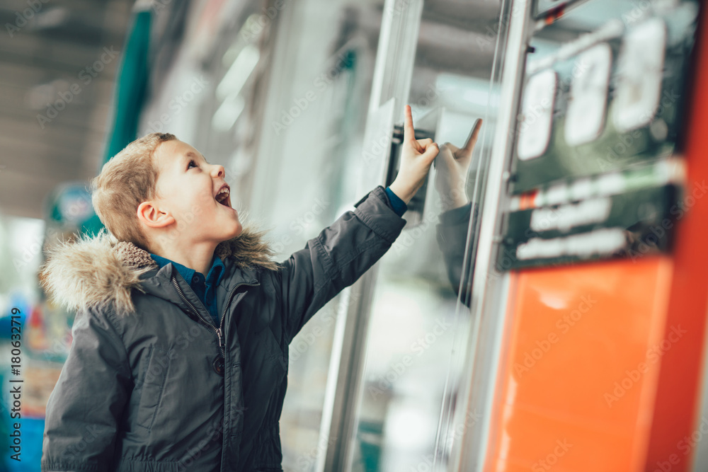 Sweet little boy, looking through a window in shop Sweet little boy, looking through a window in shop