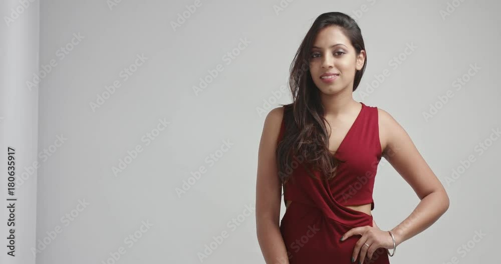 Beautiful dark haired young woman in an evening burgundy dress dressed up for Christmas party isolated on white Beautiful dark haired young woman in an evening burgundy dress dressed up for Christmas party isolated on white