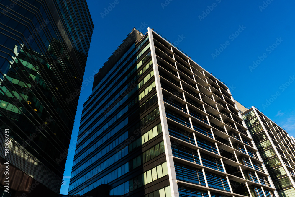 Tall building's glass window reflect daylight in town. Skycrappers modern building with modern glasses Tall building's glass window reflect daylight in town. Skycrappers modern building with modern glasses